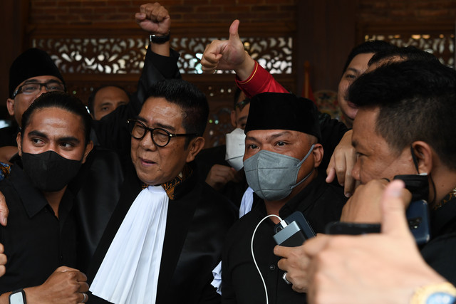 Terdakwa unlawful killing anggota Laskar FPI Briptu Fikri Ramadhan (kiri) dan Ipda M Yusmin Ohorella (kanan) meluapkan euforianya bersama Koordinator Tim Penasihat Hukum Henry Yosodiningrat (tengah) seusai sidang putusan di Jakarta, Jumat (18/3/2022) Foto: Sigid Kurniawan/ANTARA FOTO