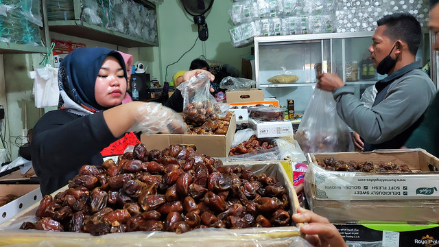 Pedagang menata kurma di salah satu toko di Jalan Kapten Mulyadi, Solo, Sabtu (02/04/2022)