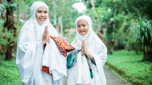 Ilustrasi ibu dan anak pakai mukena. Foto: Odua Images/Shutterstock