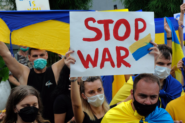 Ratusan Warga Negara Asing (WNA) asal Ukraina bersama simpatisan membawa poster bertuliskan hentikan peperangan saat aksi damai di Kantor Konsulat Ukraina, Denpasar, Bali, Selasa (1/3/2022). Foto: Nyoman Hendra Wibowo/ANTARA FOTO