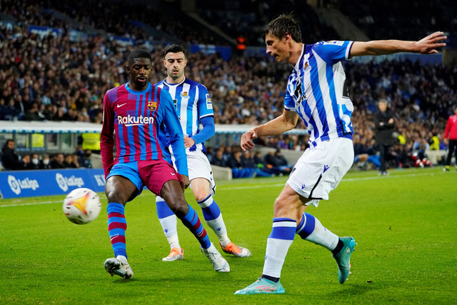 Pemain FC Barcelona Ousmane Dembele beraksi dengan pemain Real Sociedad Diego Rico dan Robin Le Normand, di Reale Arena, San Sebastian, Spanyol, Kamis (21/4/2022). Foto: Vincent West/REUTERS