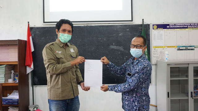 Penyerahan akun media web sekolah, Kumparan dan konten Instagram yang dilakukan oleh Dosen Pembimbing Lapangan (DPL) KKN 261, Dr. Filosa Gita Sukmono, S.Ikom., M.A. (Kiri) dan Kepala Sekolah SD Muhammadiyah Balecatur, Ahmad Baddawi S. Ag. (Kanan).