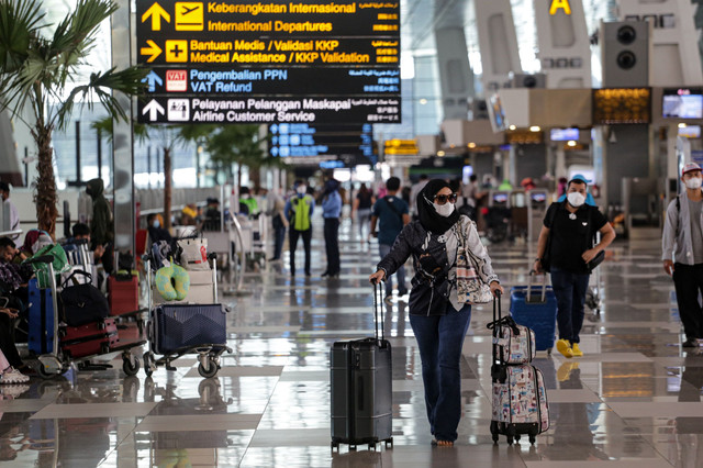 Sejumlah calon penumpang pesawat berjalan di Terminal 3 Bandara Soekarno Hatta, Tangerang, Banten, Selasa (8/3/2022).  Foto: Fauzan/ANTARA FOTO