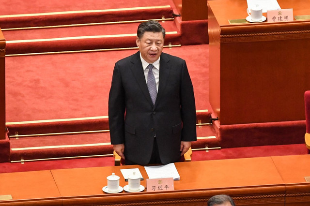 Presiden Tiongkok Xi Jinping menyanyikan lagu kebangsaan selama upacara pembukaan Konferensi Konsultatif Politik Rakyat China (CPPCC) di Aula Besar Rakyat di Beijing pada Jumat (4/3/2022). Foto: Matthew Walsh/AFP