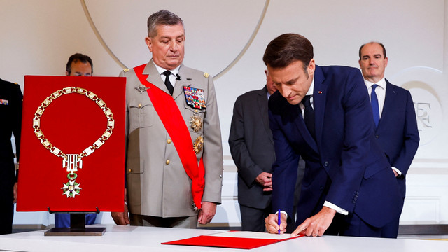 Presiden Prancis Emmanuel Macron menandatangani dokumen saat ia dilantik untuk masa jabatan kedua sebagai presiden setelah terpilih kembali, dalam upacara di Istana Elysee di Paris, Prancis, Sabtu (7/5/2022). Foto: Gonzalo Fuentes/REUTERS