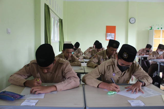 Para siswa putra madrasah sedang mengerjakan ulangan harian. Sumber: Humas PPTQ AU.