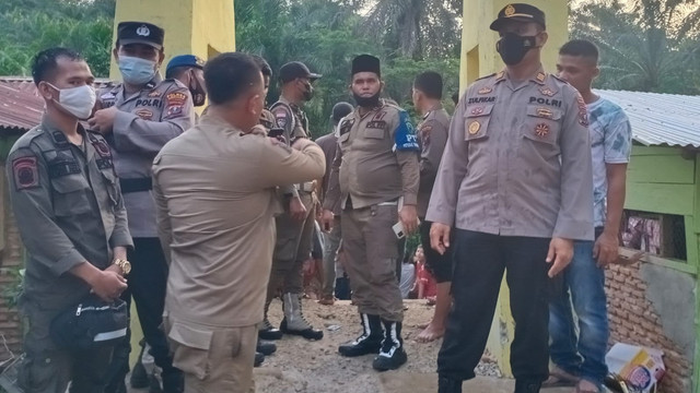 Polisi saat mengevakuasi korban rubuhnya jembatan di Paluta. Foto: Dok. Istimewa