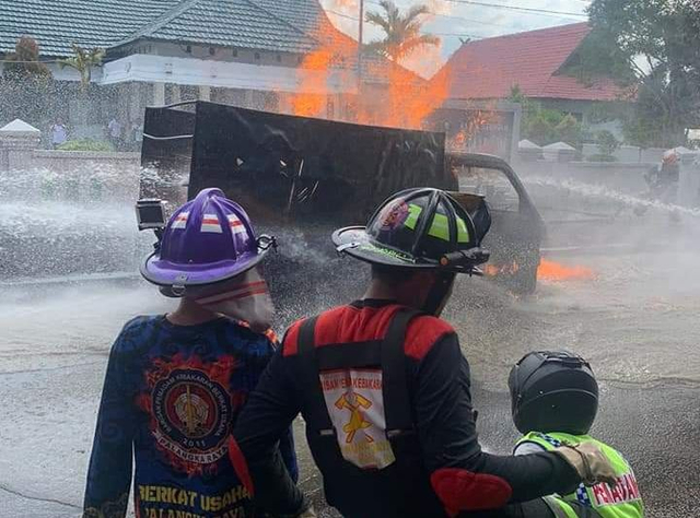 Pemadaman mobil yang terbakar di kompleks kantor Gubernur Kalteng oleh sejumlah petugas.