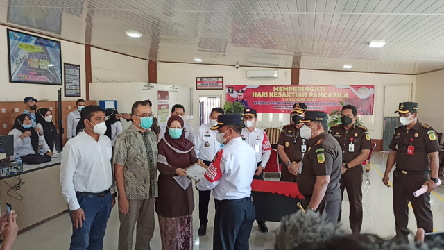 Kalapas Kelas IIA Banda Aceh Said Mahdar menyerah surat pembebasan Saiful Mahdi yang diterima oleh istrinya pada Rabu (13/10) setelah mendapat amnesti Presiden Jokowi. Foto: Husaini/acehkini
