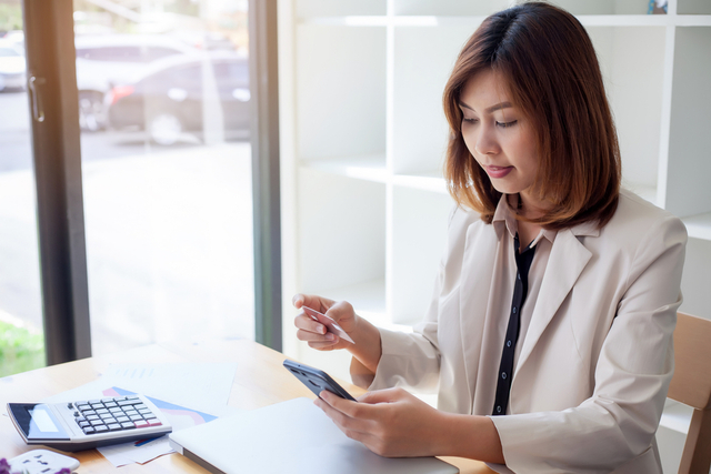 Ilustrasi perempuan melakukan investasi lewat smartphone. Foto: Shutterstock