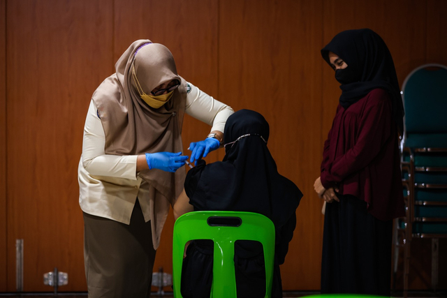 Warga Aceh menerima suntikan vaksin COVID-19 di Gedung Banda Aceh Convention Hall, Senin (11/10/2021).  Foto: Abdul Hadi/acehkini