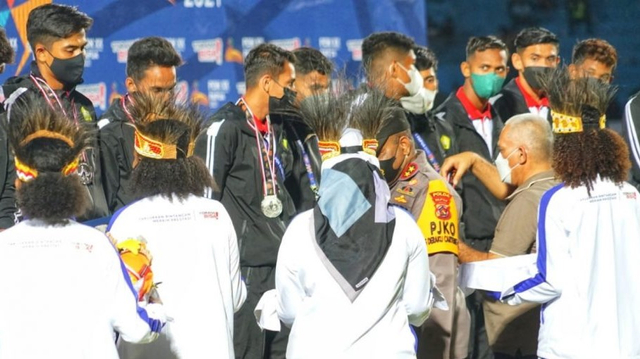 Sekda Aceh Taqwallah mengalungkan mendali perak kepada tim sepak bola Aceh usai partai final PON XX Papua 2021 di Stadion Mandala, Jayapura, Kamis (14/10) malam. Foto: Dok. Humas BPPA