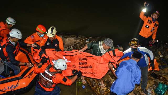 Petugas tim SAR dari BPBD Ciamis dengan dibantu warga membawa kantong jenazah korban tenggelam di Sungai Cileuer, Desa Utama, Kabupaten Ciamis, Jawa Barat, Jumat (15/10/2021).  Foto: Adeng Bustomi/ANTARA FOTO