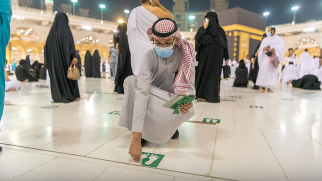 Petugas Masjidil Haram mencabut stiker jaga jarak menyusul beroperasinya masjid dalam kapasitas penuh mulai Minggu tanggal 17 Oktober 2021 Foto: Dok. gph.gov.sa