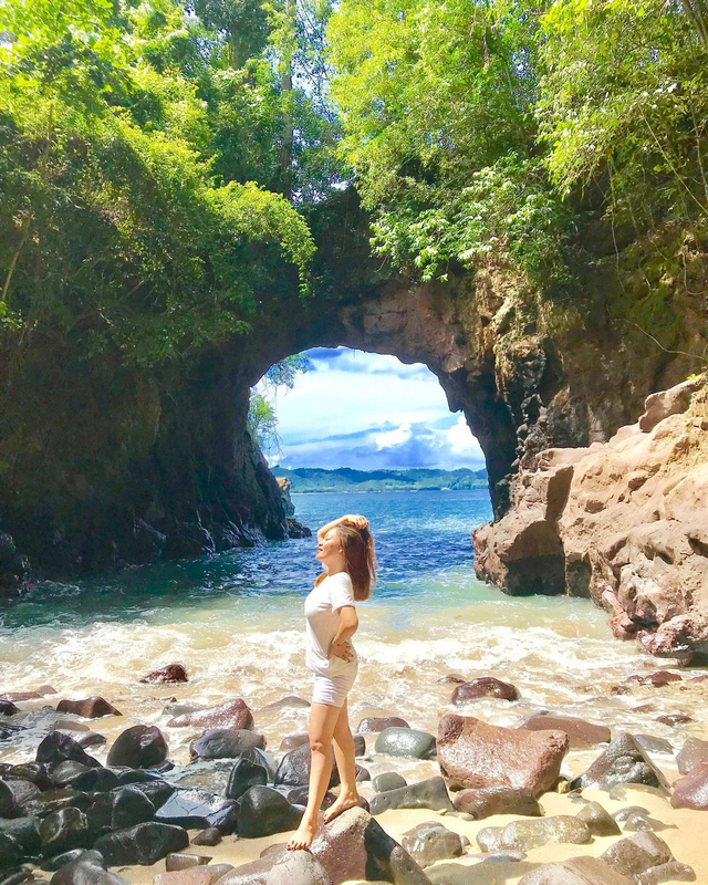 Wisatawan yang tengah menikmati keindahan salah satu pantai di Bitung. Foto: Instagram @militiakristi