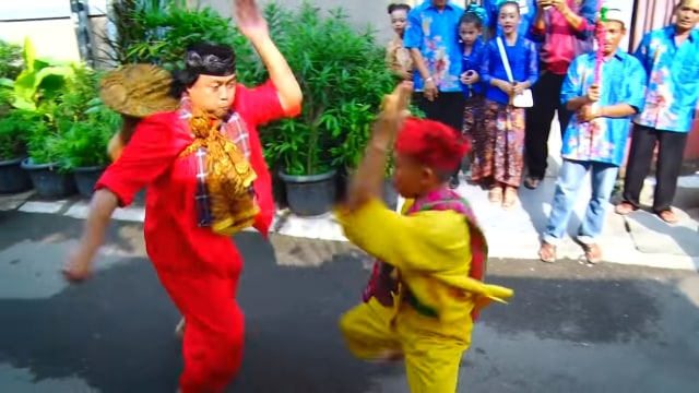 Ilustrasi tradisi Palang Pintu Betawi dengan berbalas pantun dan adu silah yang disajikan dalam sebuah prosesi pernikahan. Sumber: Kemdikbud