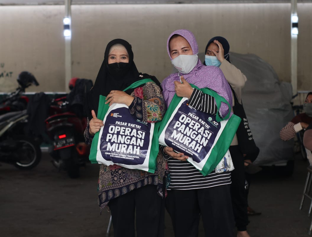 Warga Grogol Utara tersenyum bahagi setelah mendapatkan pangan murah.