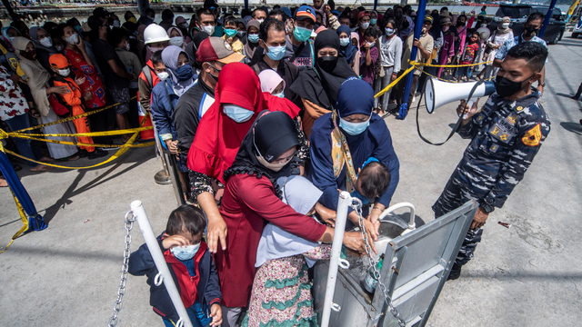 Taruna AAL memberikan informasi untuk selalu menjalankan protokol kesehatan kepada warga yang akan berkunjung ke KRI Bima Suci saat 'open ship' di Pelabuhan Pelindo III Tanjung Intan, Cilacap, Jawa Tengah, Sabtu (23/10/2021). Foto: Muhammad Adimaja/ANTARA FOTO