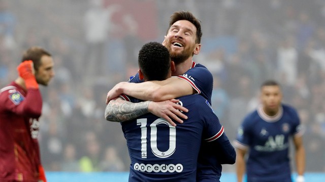 Pemain Paris St Germain Lionel Messi merayakan dengan Neymar setelah pemain Olympique de Marseille Luan Peres mencetak gol bunuh diri, di Orange Velodrome, Marseille, Prancis, Minggu (24/10). Foto: Eric Gaillard/REUTERS