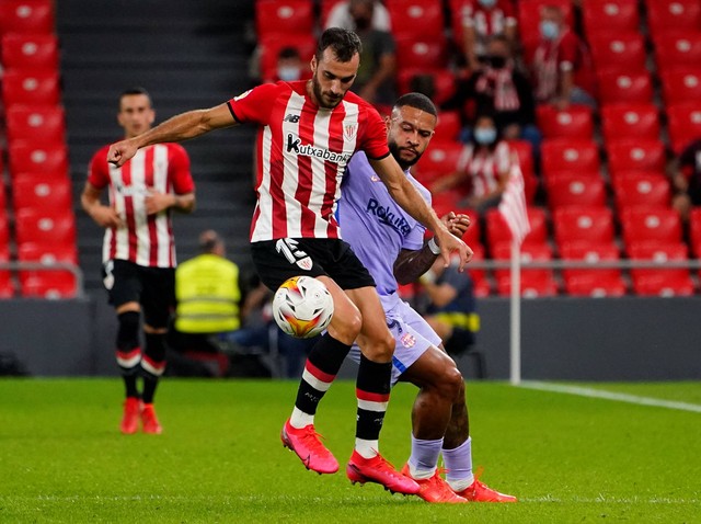 Inigo Lekue dari Athletic Bilbao beraksi dengan Memphis Depay dari FC Barcelona saat pertandingan LaLiga di San Mames, Bilbao, Spanyol. Foto: Vincent West/Reuters