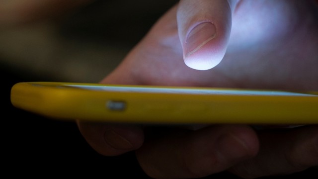 Ilustrasi menggunakan smartphone. Foto: Jenny Kane/AP Photo