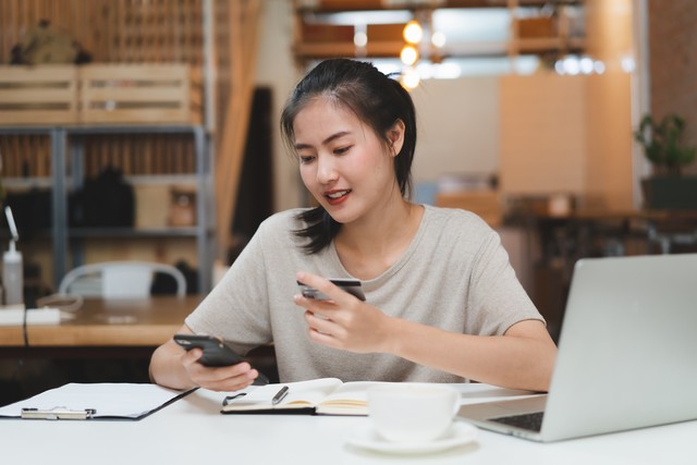 Ilustrasi perempuan menggunakan mobile banking. Foto: Shutterstock