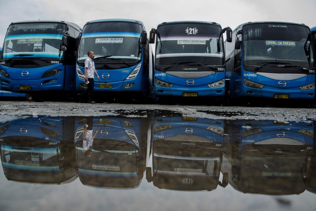 Supir berjalan di depan bus yang tidak beroperasi di pool (pangkalan) Bus Damri, Bandung, Jawa Barat, Kamis (28/10).  Foto: Novrian Arbi/ANTARA FOTO