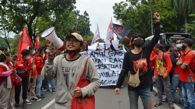Seorang yang sedang berbicara melalui pengeras suara beserta kawannya yang mengepalkan tangan. (Yudisald/Jurnalis)