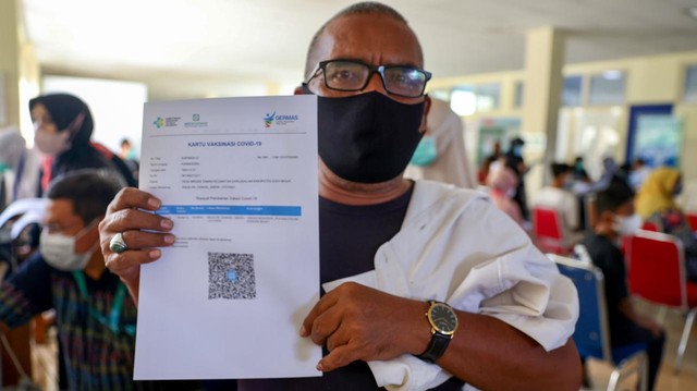 Seorang ASN Pemerintah Aceh menunjukkan sertifikat vaksin. Foto: Suparta/acehkini