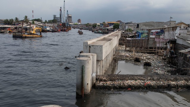 Pekerja menggunakan ekskavator untuk menyelesaikan pembangunan tanggul laut di Cilincing, Jakarta, Kamis (4/11/2021).  Foto: ANTARA FOTO/Aditya Pradana Putra
