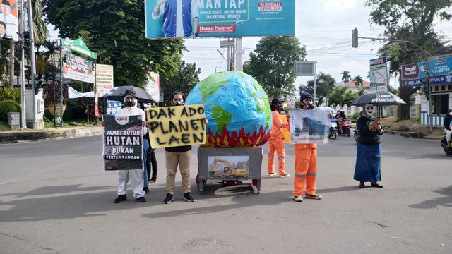 WALHI Jambi saat aksi di persimpangan jalan, menyampaikan bumi semakin panas. (Foto: M Sobar Alfahri/Jambikita)