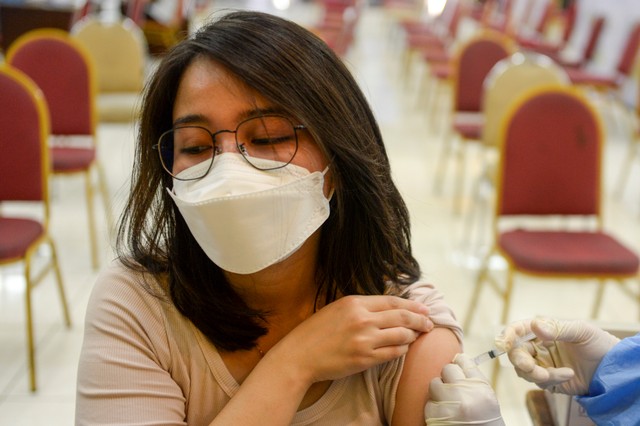 Petugas memeriksa tensi tubuh seorang warga sebelum mendapatkan suntikan vaksin COVID-19 di Sentra Vaksinasi COVID-19 di Gelanggang Remaja Pulogadung, Jakarta, Sabtu (6/11/2021). Foto: M Risyal Hidayat/ANTARA FOTO