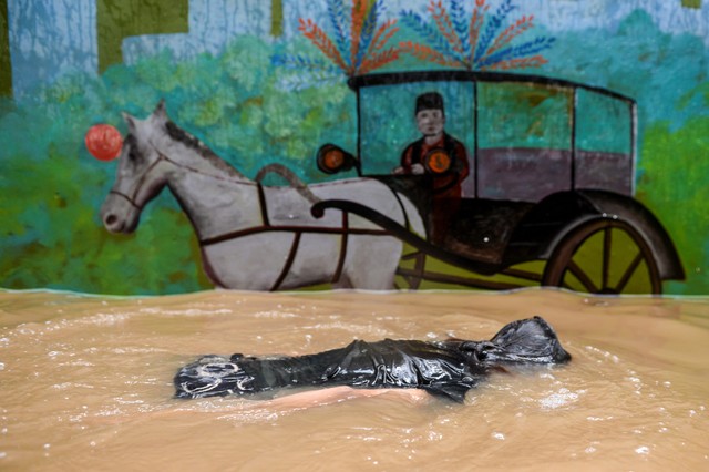 Seorang warga berenang ketika banjir merendam di kawasan Kebon Pala, Kampung Melayu, Jatinegara, Jakarta Timur, Senin (8/11/2021). Foto: M Risyal Hidayat/Antara Foto