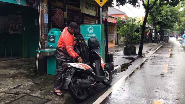 Pak Andi saat mengantarkan pesanan pelanggan (Foto:Pribadi)