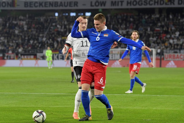 Pemain Jerman Marco Reus berebut bola dengan pemain Liechtenstein pada pertandingan Kualifikasi Piala Dunia 2022 di Volkswagen Arena, Wolfsburg, Jerman. 
 Foto: Fabian Bimmer/REUTERS
