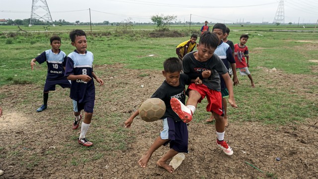 Sejumlah anak bermain sepak bola di Desa Karangrahayu, Cikarang Utara, Jawa Barat. Foto: Iqbal Firdaus/kumparan