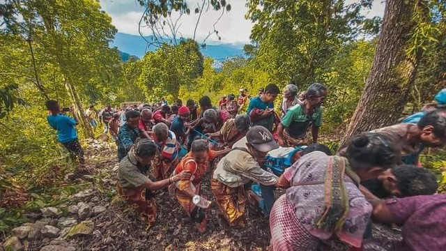 Keterangan foto: Ratusan warga Desa Sunu, menggotong patung Presiden Joko Widodo menuju puncak bukit. Sumber foto: istimewa.