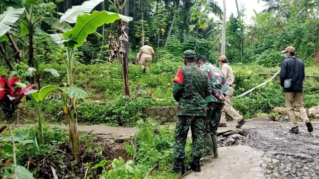 Babinsa Koramil 13/Rembang Kodim 0702/Purbalingga bersama instansi terkait meninjau lokasi tanah bergerak di Desa Panusupan yang mengakibatkan bahu jalan retak. Foto: Istimewa