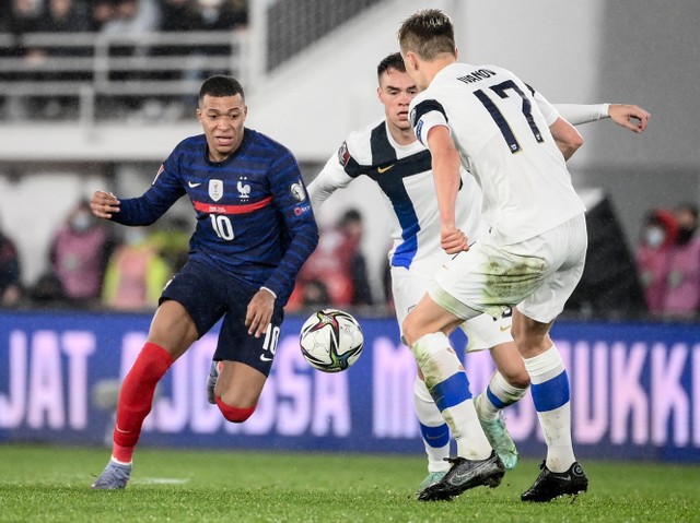 Pemain Prancis Kylian Mbappe duel dengan pemain Finlandia Robert Ivanov saat pertandingan Grup D kualifikasi Piala Dunia Qatar 2022di Stadion Olimpiade di Helsinki. Foto: Franck Fife/AFP