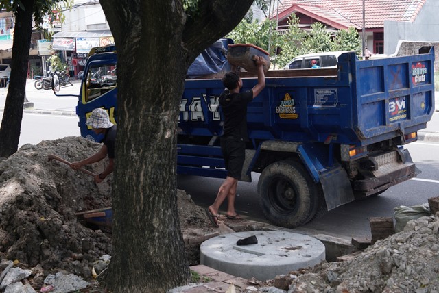 Pekerja menyelesaikan proyek galian sumur resapan di kawasan Duren Sawit, Jakarta Timur, Selasa (18/11/2021). Foto: Jamal Ramadhan/kumparan