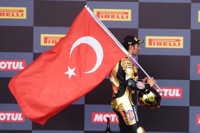 Pembalap tim Pata Yamaha With Brixx WorldSBK Toprak Razgatlioglu mengibarkan bendera Turki seusai balapan pertama (race 1) WSBK seri Indonesia 2021di Sirkuit Mandalika, Lombok Tengah, Nusa Tenggara Barat (NTB), Minggu (21/11).  Foto: Andika Wahyu/ANTARA FOTO