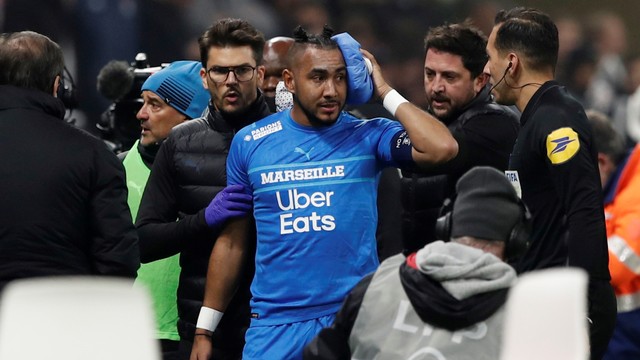 Pemain Olympique de Marseille Dimitri Payet berjalan keluar lapangan karena cedera setelah terkena botol air yang dilemparkan oleh seorang penggemar, di Stadion Groupama, Lyon, Prancis, Minggu (21/11). Foto: Benoit Tessier/REUTERS