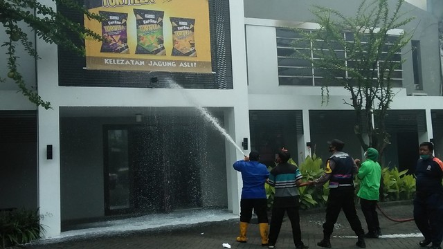 Petugas pemadam kebakaran saat memadamkan api yang membakar pabrik kacang dua kelinci Pati, Jawa Tengah, Selasa (23/11). Foto: Polsek Margorejo