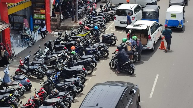 Kendaraan parkir hingga 1/4 lebar jalan raya di dekat Pasar Jaya Pramuka, Jakarta, Selasa (23/11/2021). Foto: Jamal Ramadhan/kumparan