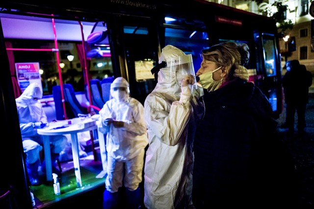 Seorang petugas medis melakukan pemeriksaan tes virus corona di Bratislava, Slovakia. Foto: VLADIMIR SIMICEK / AFP