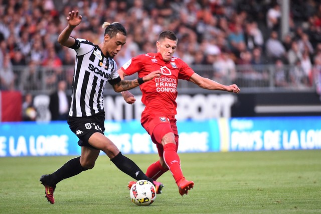 Pemain depan Angers asal Prancis Billy Ketkeophomphone (kiri) berebut bola dengan gelandang Caen asal Prancis Jonathan Delaplace selama pertandingan sepak bola L1 Prancis. Foto: AFP