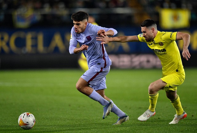 Abde Ezzalzouli dari FC Barcelona beraksi dengan Moi Gomez dari Villarreal pada pertandingan LaLiga antara Villarreal melawan FC Barcelona di Estadio de la Ceramica, Villarreal, Spanyol - 27 November 2021. Foto: Pablo Morano/REUTERS
