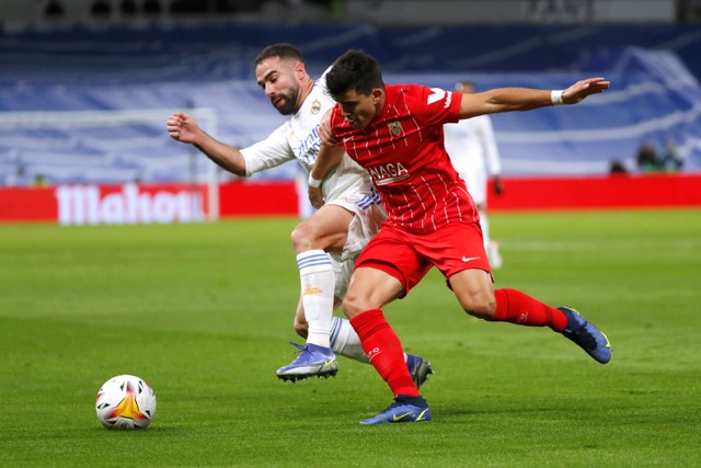 Pemain Real Madrid Dani Carvajal berebut bola dengan pemain Sevilla pada pertandingan lanjutan Liga Spanyol di Santiago Bernabeu, Madrid, Spanyol. Foto: Susana Vera/REUTERS