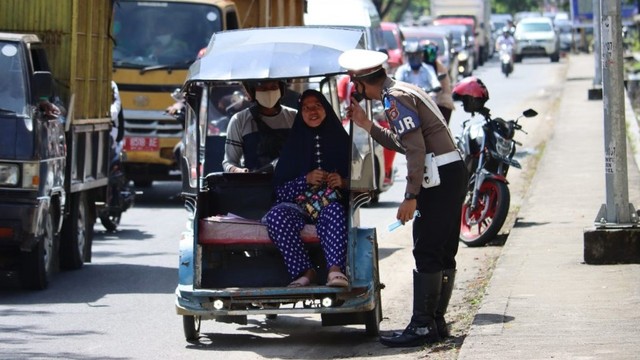 Salah seorang aparat Polda Gorontalo saat mengimbau warga untuk taat prokes. Selasa, (30/11). Foto: Dok TribrataNews