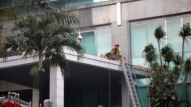 Petugas pemadam kebakaran mengevakuasi korban di lokasi kebakaran di gedung Cyber, Kuningan, Jakarta Selatan, Kamis (2/12/2021). Foto: Aditia Noviansyah/kumparan